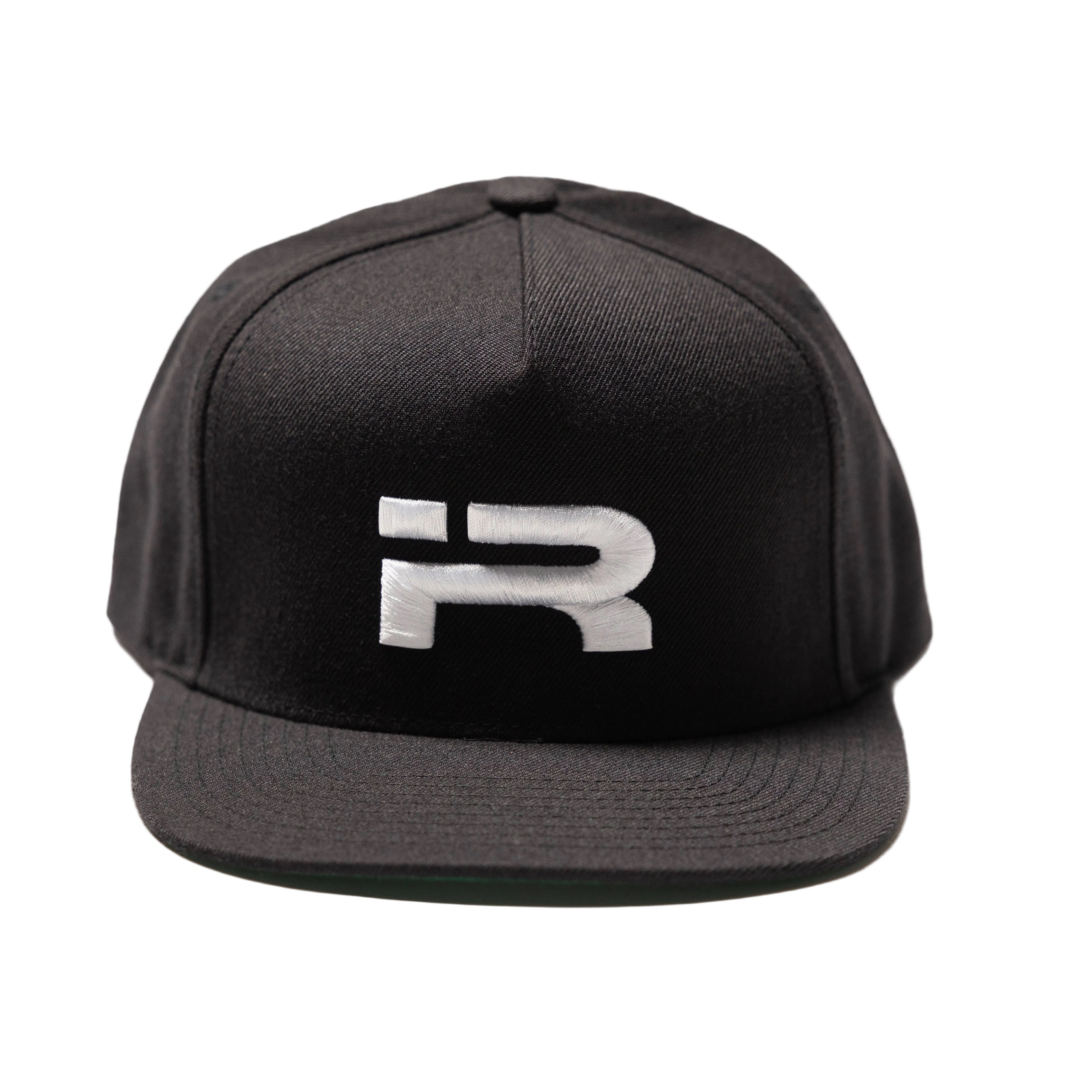 A black flat-brim snapback cap featuring a stylized white embroidered letter 'R' on the front, set against a plain white background.